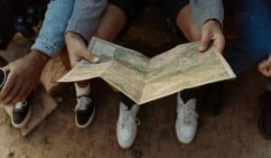 Close-up of a group exploring a map, planning a travel adventure while sitting outdoors. — Photo by cottonbro studio on Pexels