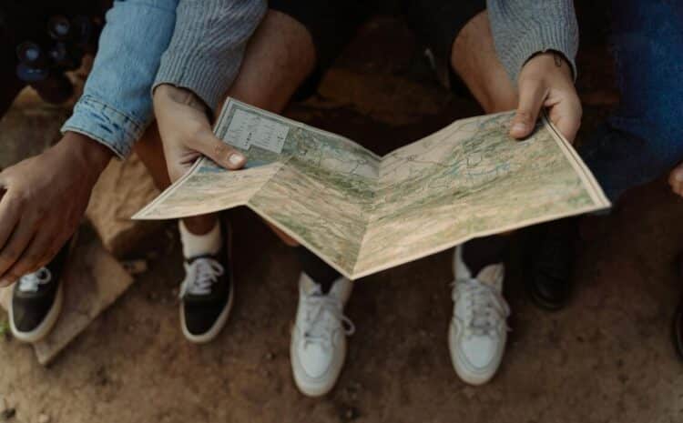 Close-up of a group exploring a map, planning a travel adventure while sitting outdoors. — Photo by cottonbro studio on Pexels