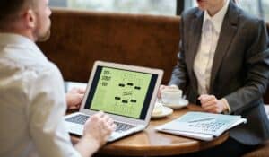A man and woman engaged in a business meeting discussing SEO strategy in a cozy cafe setting. — Photo by Jack Sparrow on Pexels