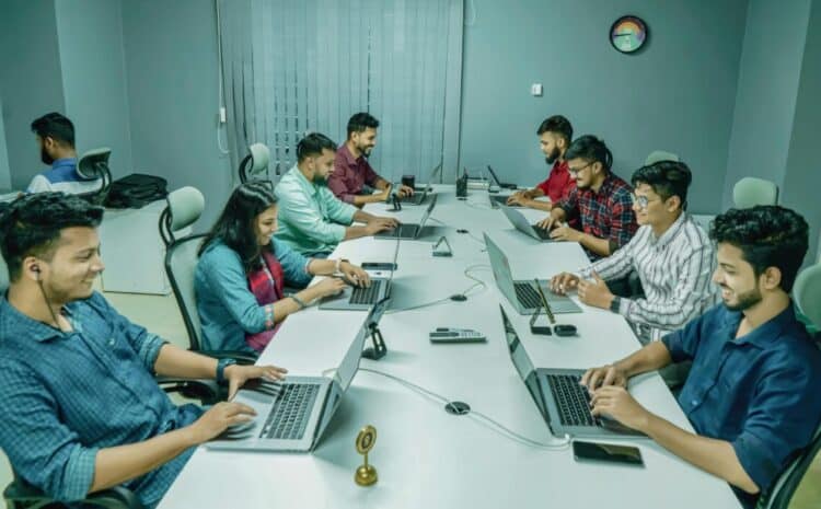 Group of professionals collaborating in a modern office setting on laptops and digital devices. — Photo by Ofspace LLC, Culture on Pexels