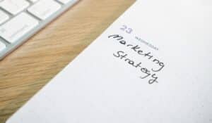 Close-up of a planner with 'Marketing Strategy' handwritten alongside keyboard. — Photo by Walls.io on Pexels