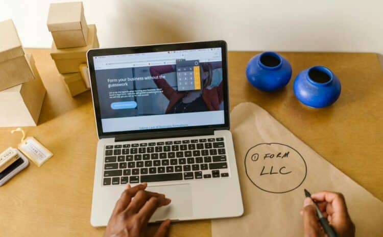 Workspace with laptop, packaging, and handwritten LLC notes, ideal for a small business startup scene. — Photo by RDNE Stock project on Pexels